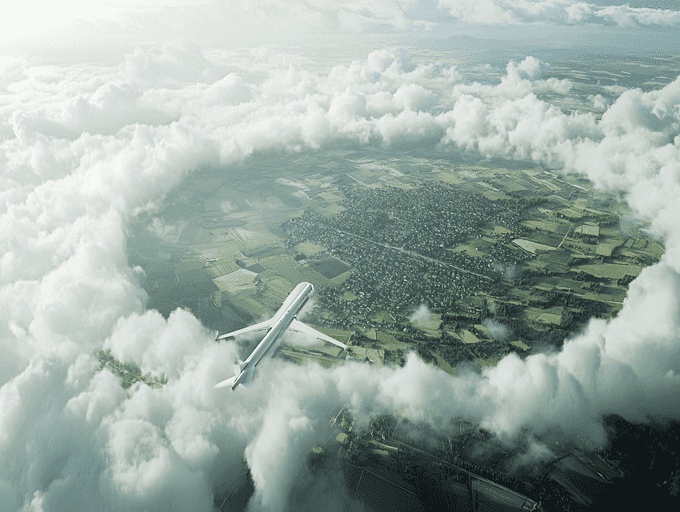 A commercial airplane flying over a scenic landscape with dramatic clouds