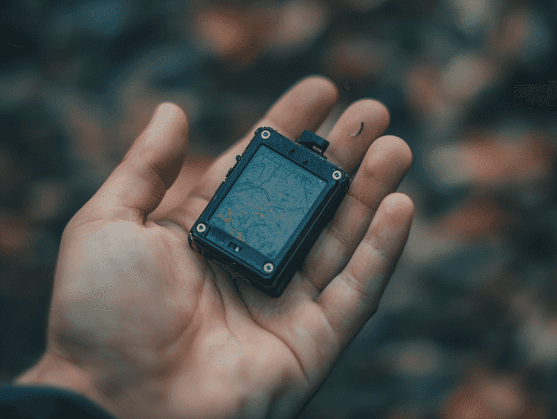 A car parked in a driveway with a suspicious device underneath